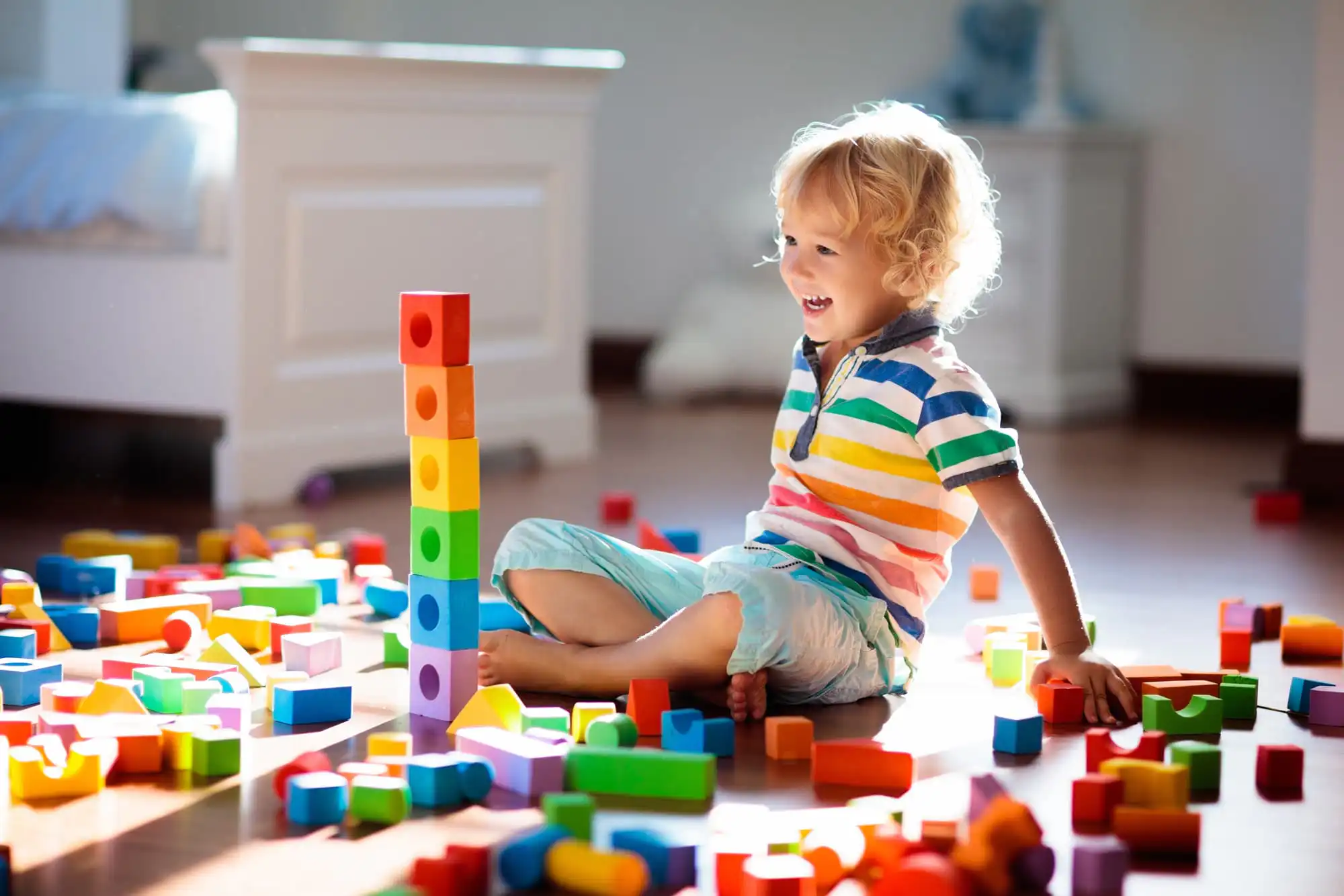 child smiling while playing blocks